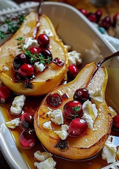Baked pears topped with feta cheese, honey, and cranberries on a plate