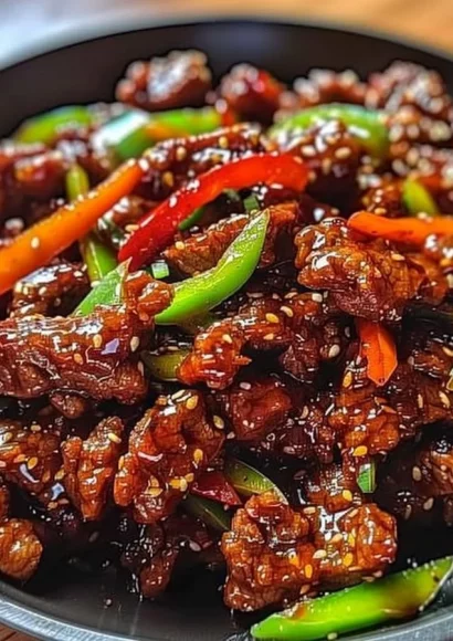 Delicious crispy chilli beef dish garnished with peppers and sesame seeds
