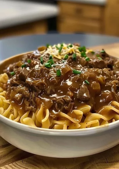 Delicious bowl of French onion beef and noodles garnished with herbs