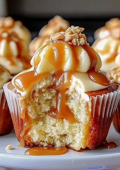 Gooey salted caramel cream cheese cupcakes topped with drizzled caramel.