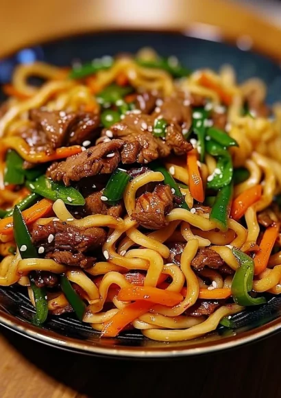 Plate of homemade beef lo mein with vegetables and beef slices