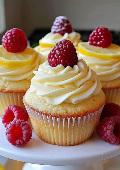 Raspberry Lemon Cupcakes topped with lemon frosting and fresh raspberries