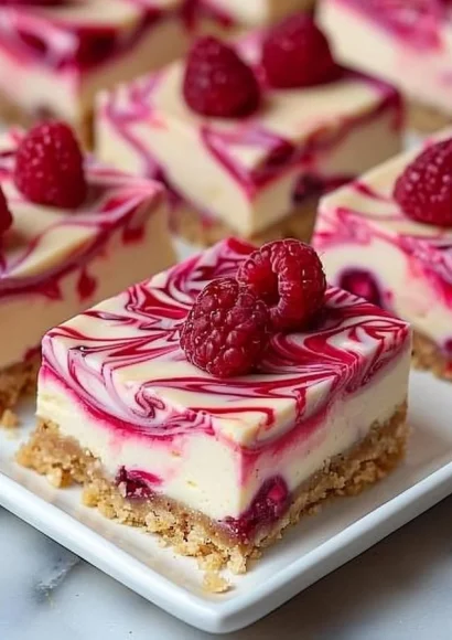 Raspberry swirl cheesecake bars with a creamy texture and vibrant topping.