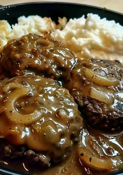 Smothered hamburger steak with gravy and sides on a plate